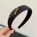 Elegantes schwarzes gepolstertes Stirnband mit goldumrandeter 'FASHION'-Logo-Verzierung. - Schwarz