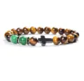Detailed close-up of tiger's eye, jade and cross beaded bracelet showing fine textures. - 17