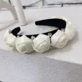Elegant 3D white fabric rose headband with rhinestones on a soft black velvet base. - Off White