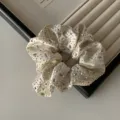 Elegante coletero de satén blanco roto con diamantes de imitación brillantes para un look chic. - Coletero / Blanco Roto
