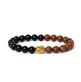 Detailansicht des Perlenarmbands mit schwarzen und Holzperlen sowie einem goldenen Buddha. - Maserstein & Schwarzer Stein