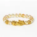 Vue détaillée du bracelet Pixiu doré avec perles de cristal claires et gravures sacrées. - Cristal 4