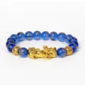 Gros plan sur le détail du bracelet de perles bleues avec pendentif Piyao et mantras. - Cristal Bleu 13