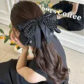 Détail rapproché d'une grande pince à cheveux élégante avec un nœud à pois noirs - Pince à Pois Style Français / Noir