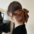 Grande pince à cheveux en satin marron avec nœud et perles portés par un modèle - Style Pendentif Perlé Texturé Marron