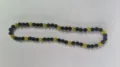 Detailed view of black and yellow Shamballa disco ball bead necklace on white surface. - Black Yellow 2