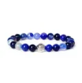 Detailed close-up view of natural blue agate gemstone beads and vintage engraved metal spacer. - Blue Agate