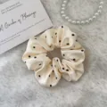Chouchou élégant en satin crème à pois noirs avec des finitions à bords volantés. - L / Pois Basique