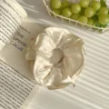 Chouchou élégant en satin beige avec des bords dorés festonnés pour femmes et filles. - Blanc