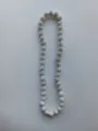 Detailed macro shot of a Shamballa necklace featuring white clay disco ball beads with silver stones - Pure White