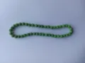 Close-up detail of a green Shamballa necklace with sparkling crystal encrusted clay beads - Verdant