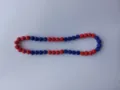 Detailed macro view of red and blue rhinestone clay beads on a sparkling Shamballa necklace - Red Blue Patchwork