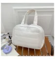 Vista dettagliata della grande borsa da trucco bianca trapuntata su una panca di legno - 31*19.5*21cm / Bianco