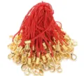 Detail view of red nylon mobile phone straps with golden metal lobster claw clasps for DIY crafts. - Red
