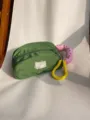 Macro detail of a green nylon cosmetic bag with a pink numeric handle and yellow coil - Green Small