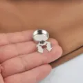 Detail view of a silver polished metal sew-free button cover for shirt collars and cuffs. - Geometric Button Cover / White Gold