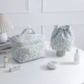 Detailed view of the light blue floral quilted makeup bag and matching drawstring pouch. - Square Handbag / L / White Base Blue Orchid