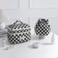 Detailed view of the black and white checkered quilted cosmetic bag set on a desk - Black & White Checkerboard