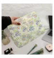 Detail view of floral quilted cotton cosmetic bag showing texture and hand-held scale - M / 25x18x7cm / Green Flower