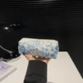Detailed handheld view of a cute blue floral quilted cotton makeup bag for travel - S / 19x7x6cm / Begonia Flower