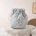 A close-up view of a floral quilted drawstring makeup bag on a white display stand - 12.5*13.5*19cm / White Base Blue Orchid