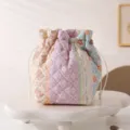 Detailed macro view of quilted floral drawstring makeup bag placed on white cloud pedestal - 12.5*13.5*19cm / Contrast Color