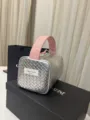 Detail einer silber-rosa geflochtenen Kosmetiktasche mit Tragegriff und Reißverschluss. - Gewebtes Silber