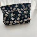 Detailed view of fresh embroidered daisy flowers on a black canvas cosmetic bag - Makeup Bag / 25x18x5cm / Black