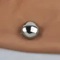 Close-up of a fashionable round metallic glossy brooch on brown fabric. - Silver