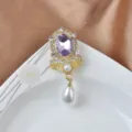 Nahaufnahme einer Magnetbrosche mit lila Edelstein, Kristallen und Perlenanhänger. - Violetter Amethyst Stil