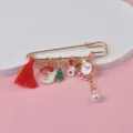 Detailed view of Christmas charms including Santa Claus and reindeer on a gold pin - Tassel