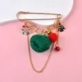 Detailed macro view of a Christmas brooch with a green knitted ball and festive charms. - Hat