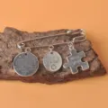 Detaillierte Nahaufnahme einer Retro-Silberbrosche mit gravierten Anhängern auf Holz. - Freundschaft Puzzle Lebensgeschenk Stil (04款)