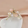 Detailed view of an elegant gold-tone owl brooch with pearls and enamel flowers. - Owl Shape (240910-LX03)