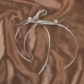 Detail von eleganten weißen langen Schleifenohrringen mit Perlen auf brauner Seide - Weiße Schleife (925er Sterlingsilber-Ohrstecker)