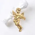 Primer plano de un broche de ángel dorado tocando el violín sobre un busto blanco. - Dorado