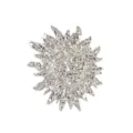 Detailed macro view of a vintage silver molten metal sun face brooch with irregular rays - Silver