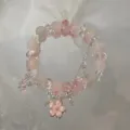 Close-up detail of the pink beaded bracelet with silver chains and a sweet flower pendant. - Spring Peach Blossom Bracelet (S6233) / Pink