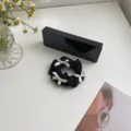 Elegante zwarte stoffen scrunchie met drie witte lintstrikken op een wit bureau - Strik Kant Stijl (220412) / Zwart
