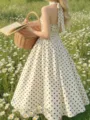 Detailed view of women's floral field photoshoot showcasing a vintage polka dot halter dress. - S / Milky White