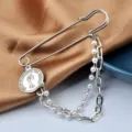 Close-up of hip-hop safety pin brooch with pearl chain and Queen Elizabeth coin pendant - Queen Portrait Style