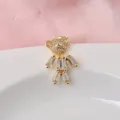 Close-up of a gold-toned teddy bear brooch featuring sparkling crystal baguettes. - Gold