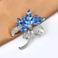 Close-up view of a sparkling blue crystal flower brooch with rhinestone bow detail - Bouquet