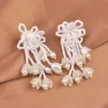 Detailaufnahme von zarten weißen Maiglöckchen-Ohrringen mit Perlen und Perlen-Quasten - Weiß