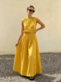 Detail view of the elegant yellow sleeveless top and pleated maxi skirt in outdoor setting. - S / Sunflower Yellow