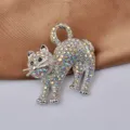 Dettaglio di una spilla a forma di gatto in argento con strass colorati su raso - Bianco