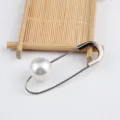 Nahaufnahme einer eleganten silbernen Sicherheitsnadel-Brosche mit einer großen weißen Perle - Stil mit großer Perle / Silber