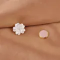Nahaufnahme einer weißen Muschelblumen-Magnetbrosche mit goldener Rückseite auf Stoff - Weiß Muschel Fünfblättrige Blume
