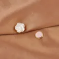 Nahaufnahme einer magnetischen Brosche aus natürlicher Muschelblüte auf Satinstoff. - Rose