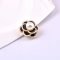 Detailed macro view of a magnetic camellia brooch with pearl center and enamel finish - Black